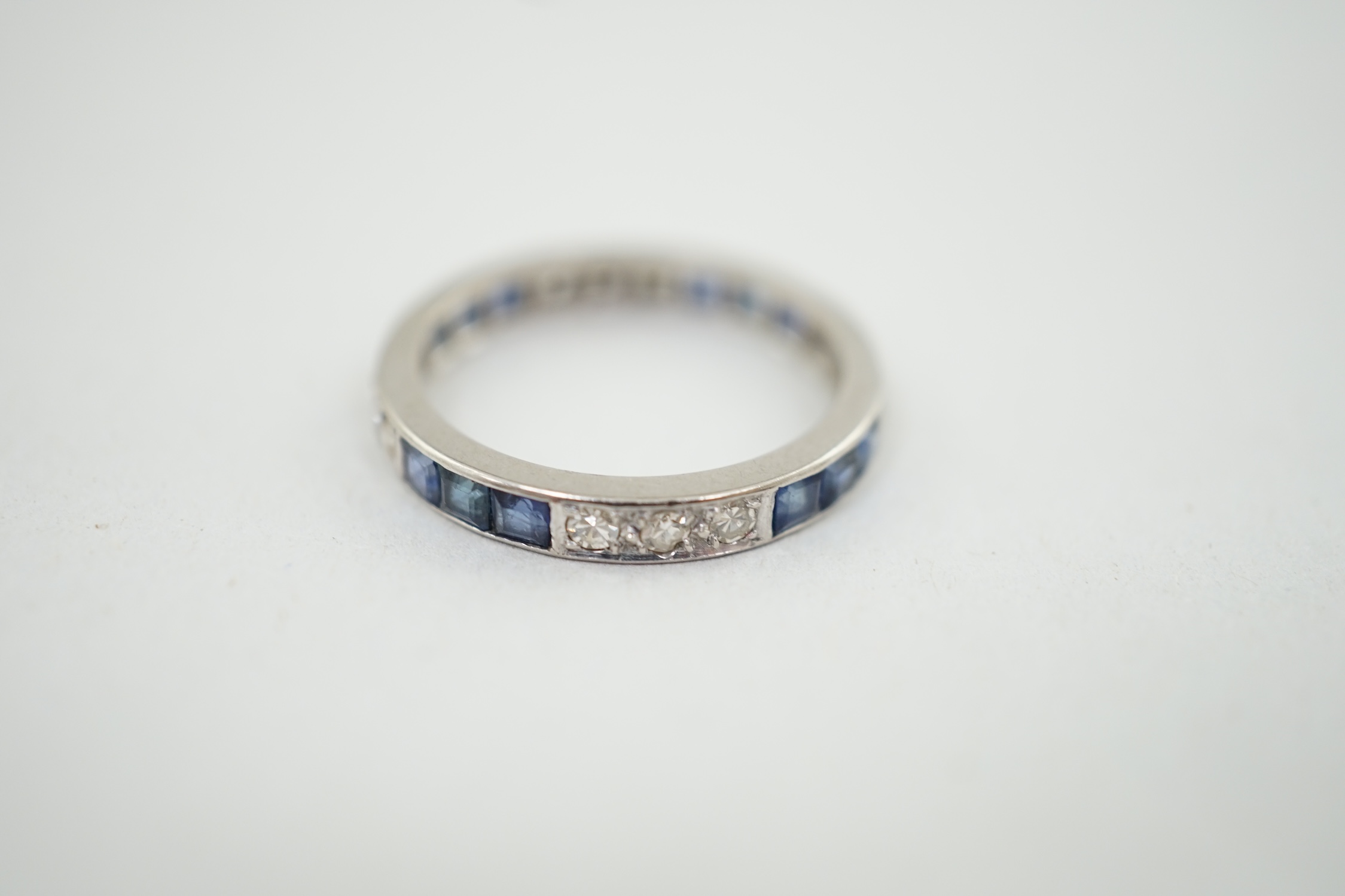 A white gold, twelve stone sapphire and twelve stone diamond set full eternity ring